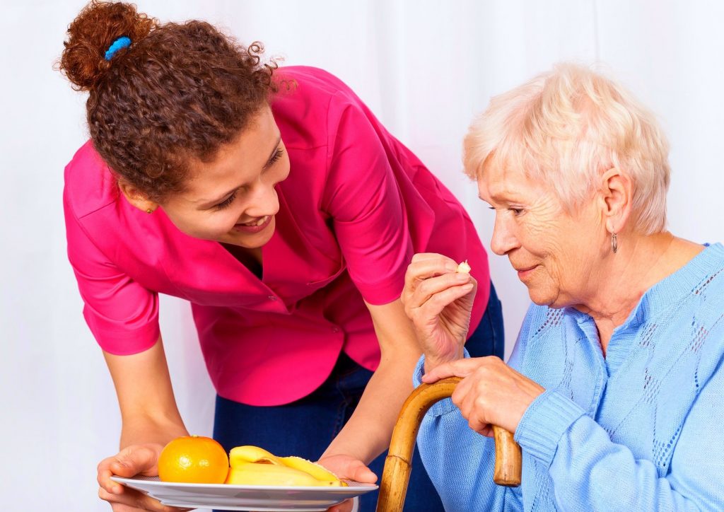 Nurse Next Door Nurse Giving a Senior Woman Food