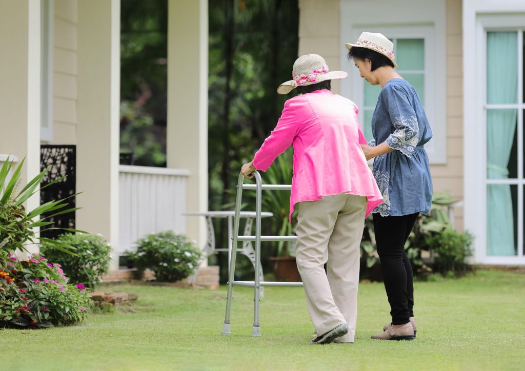 Elderly woman walking with her Caregiving daughter