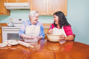 A Nurse Next Door Caregiver helps her client prepare a meal