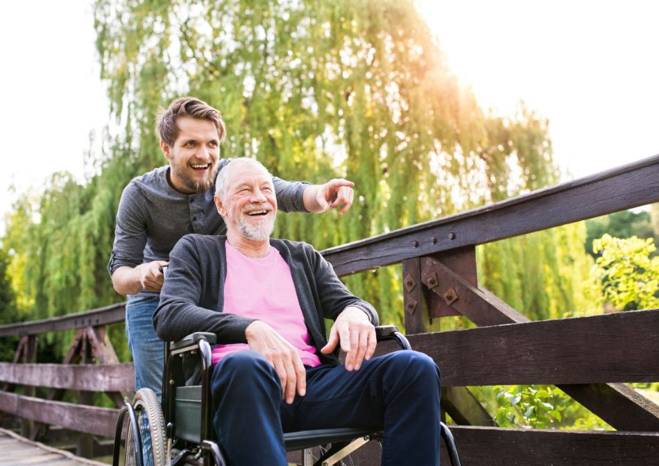 Man in wheelchair with his carer laughing
