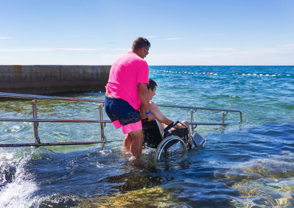 Young man in wheelchair at wheelchair accessible beach