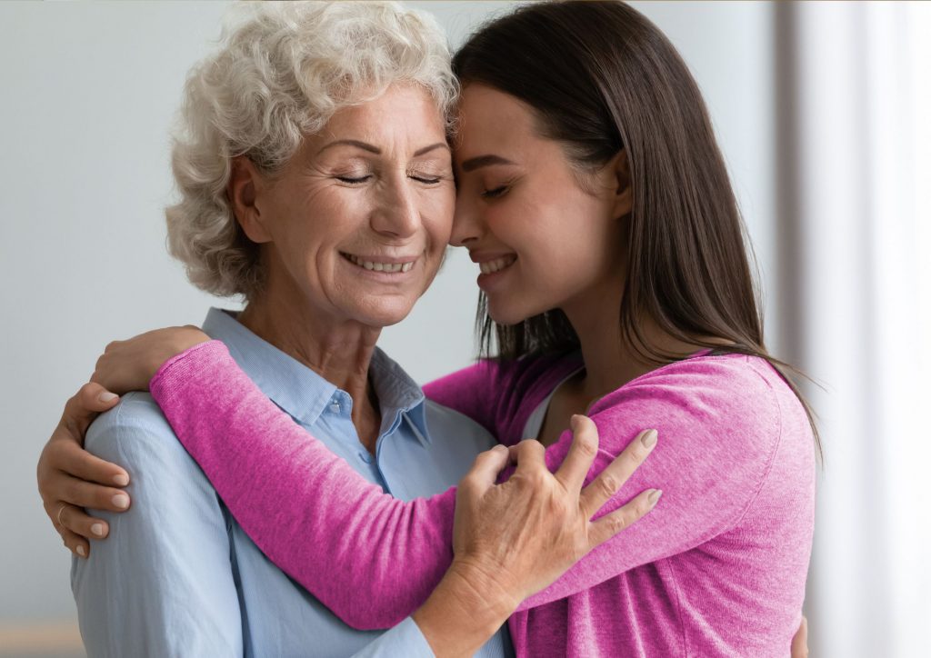 Daughter hugging elderly mum