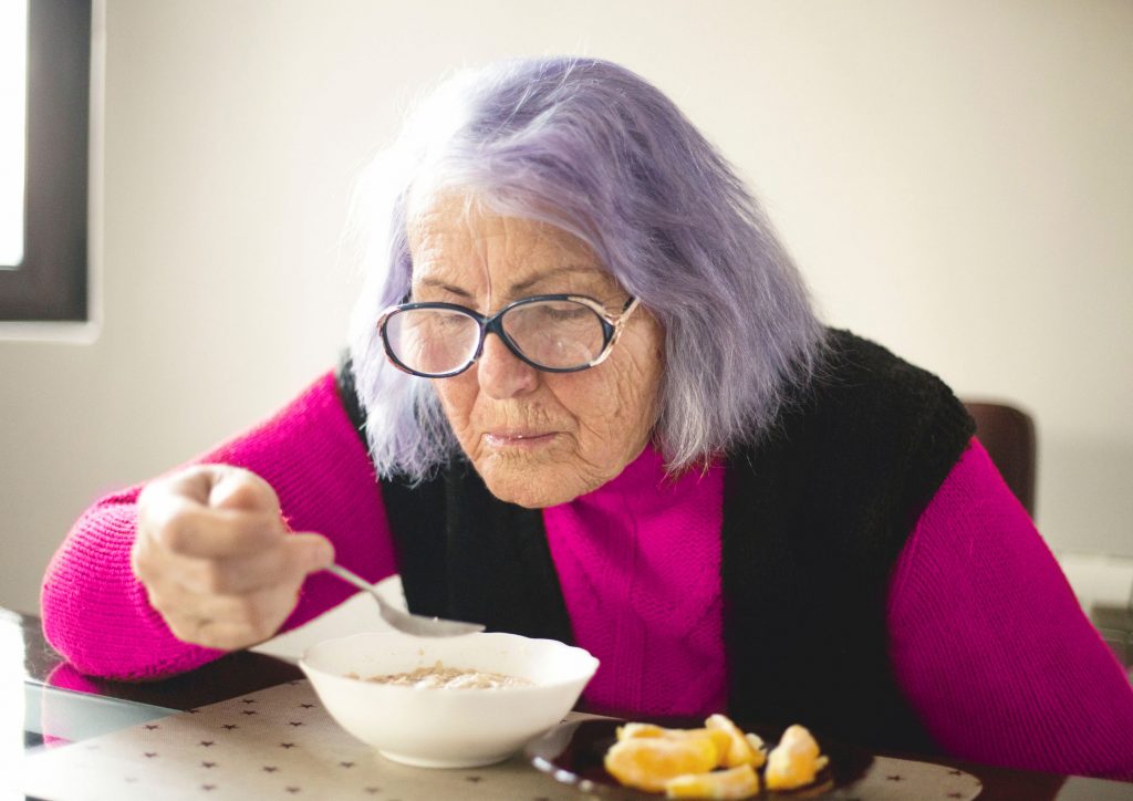 Sad Senior Woman struggling to eat