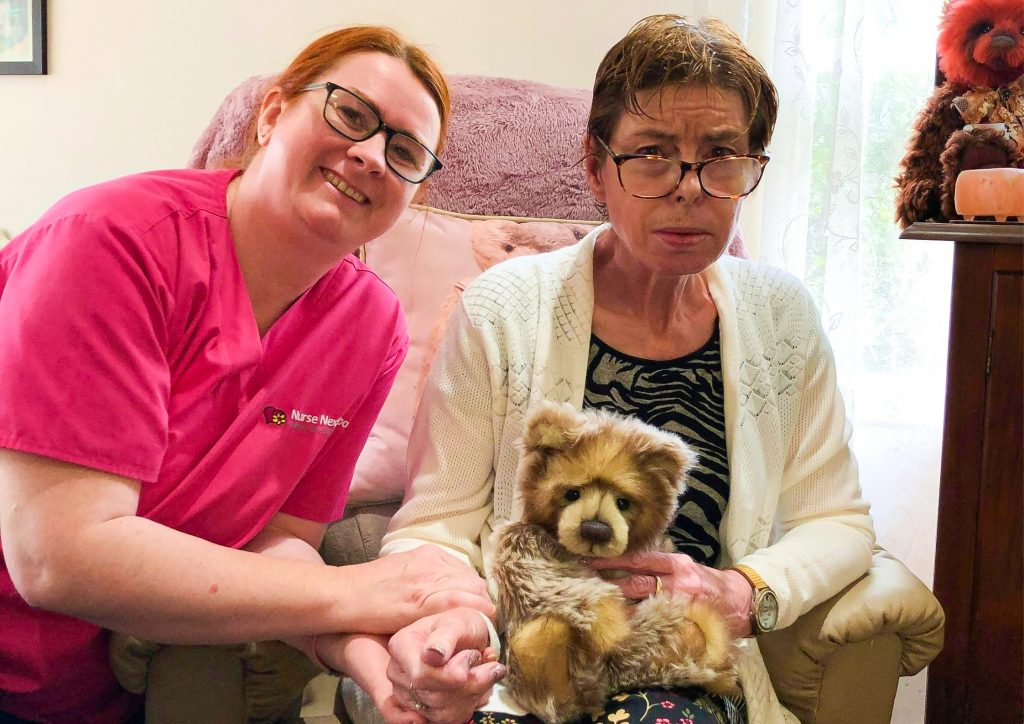 Helen with her Caregiver holder a teddy bear 1