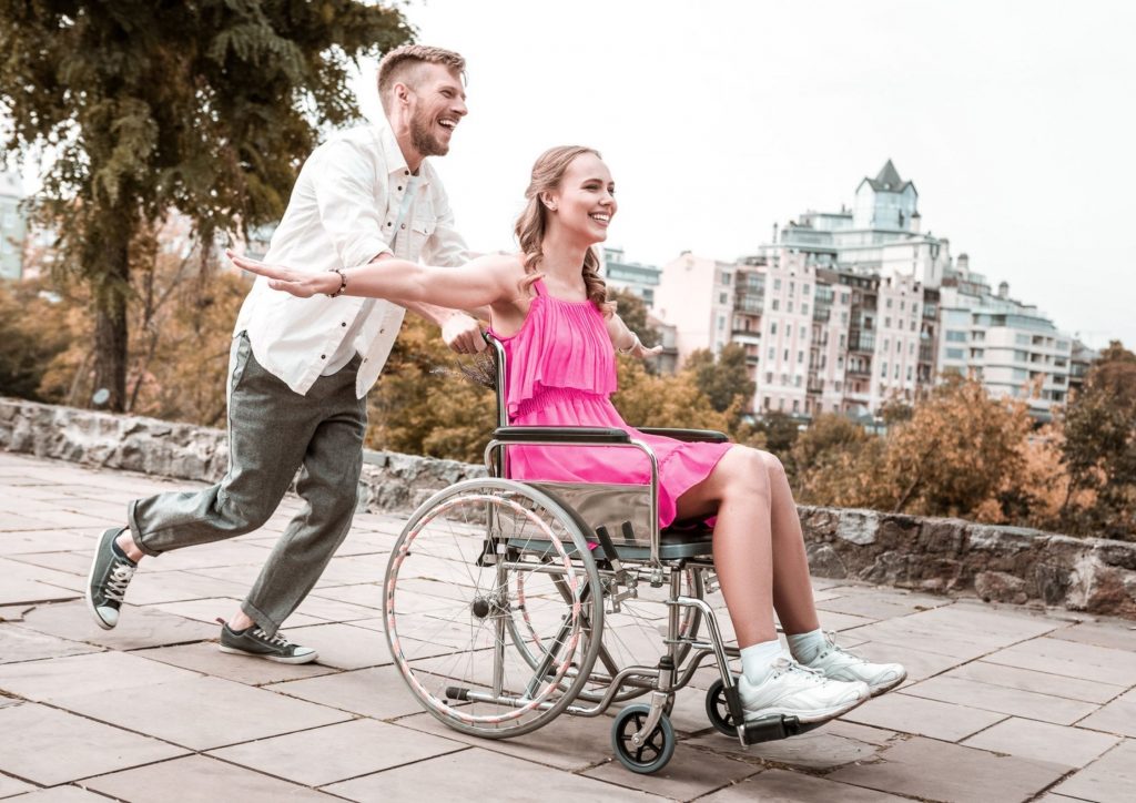 Man running with woman in wheelchair