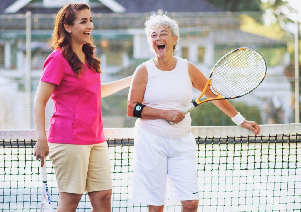 Elderly Woman Playing Tennis with her Caregiver