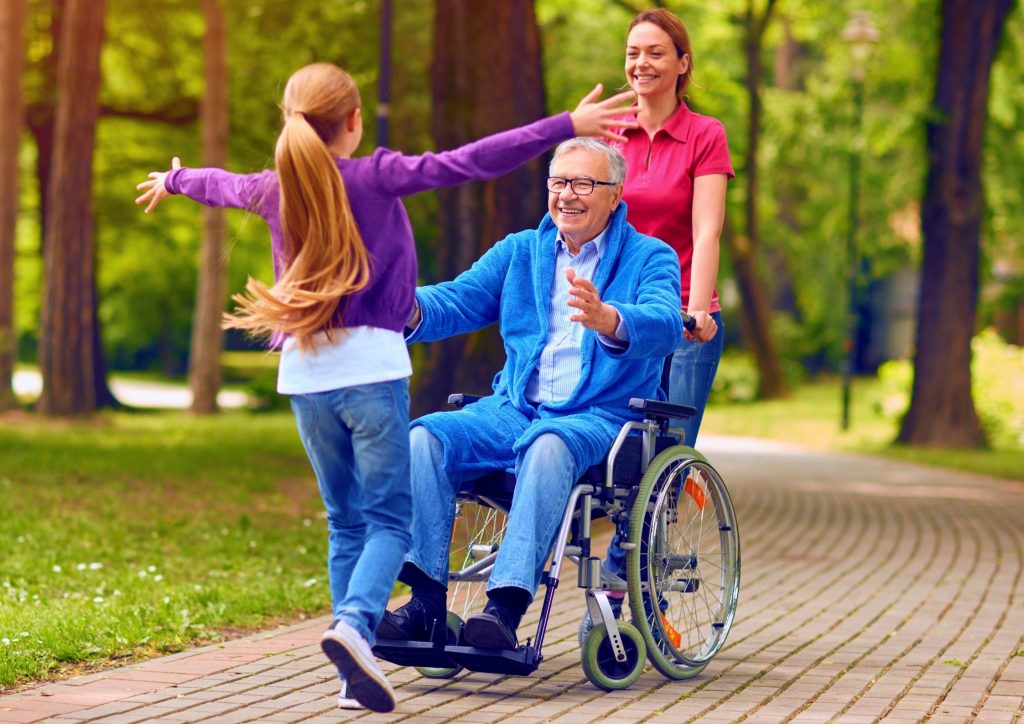 Man in wheelchair hugging grandchild