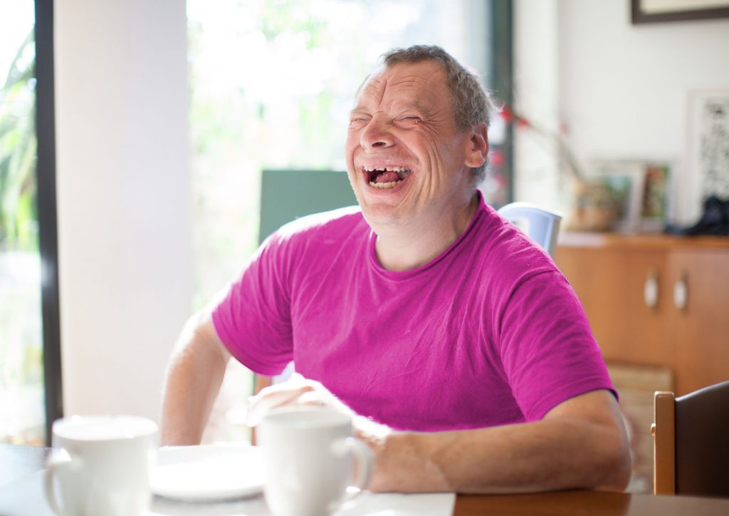 Older man with Down Syndrome laughing