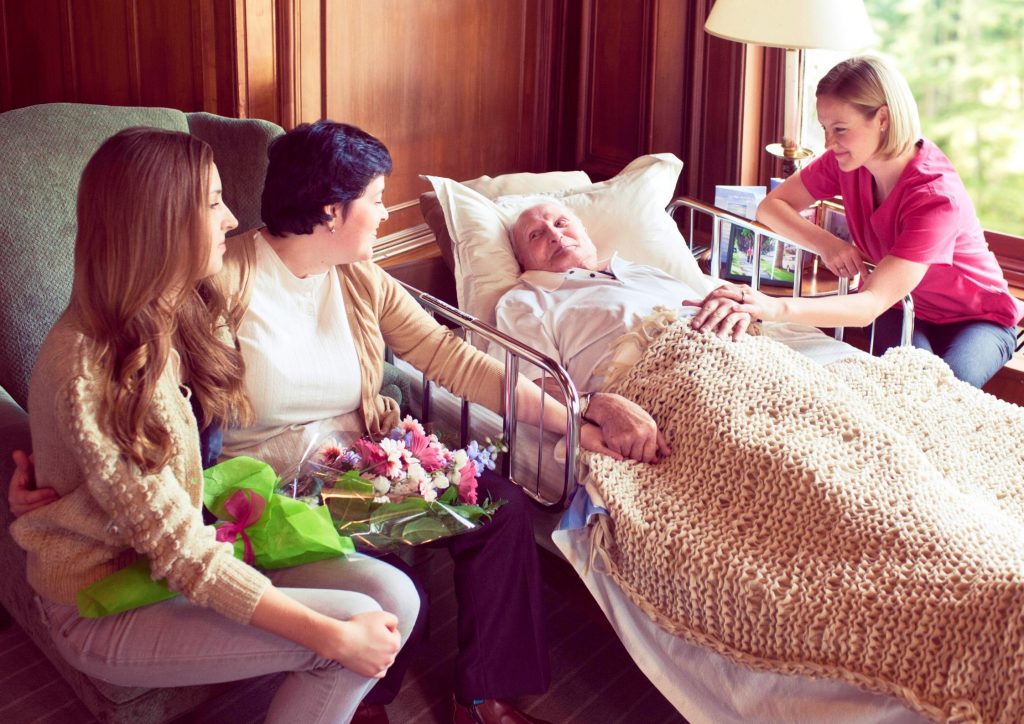 Palliative Client at Home with Home Care Nurse and Family