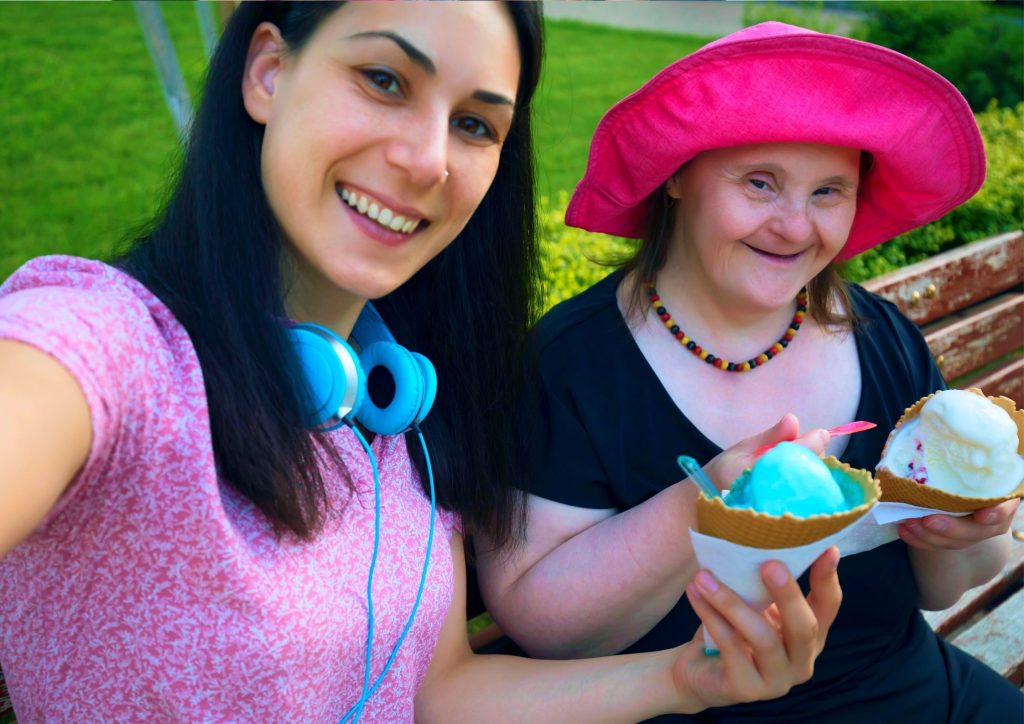 Woman with Down Syndrome sharing ice cream with her friend