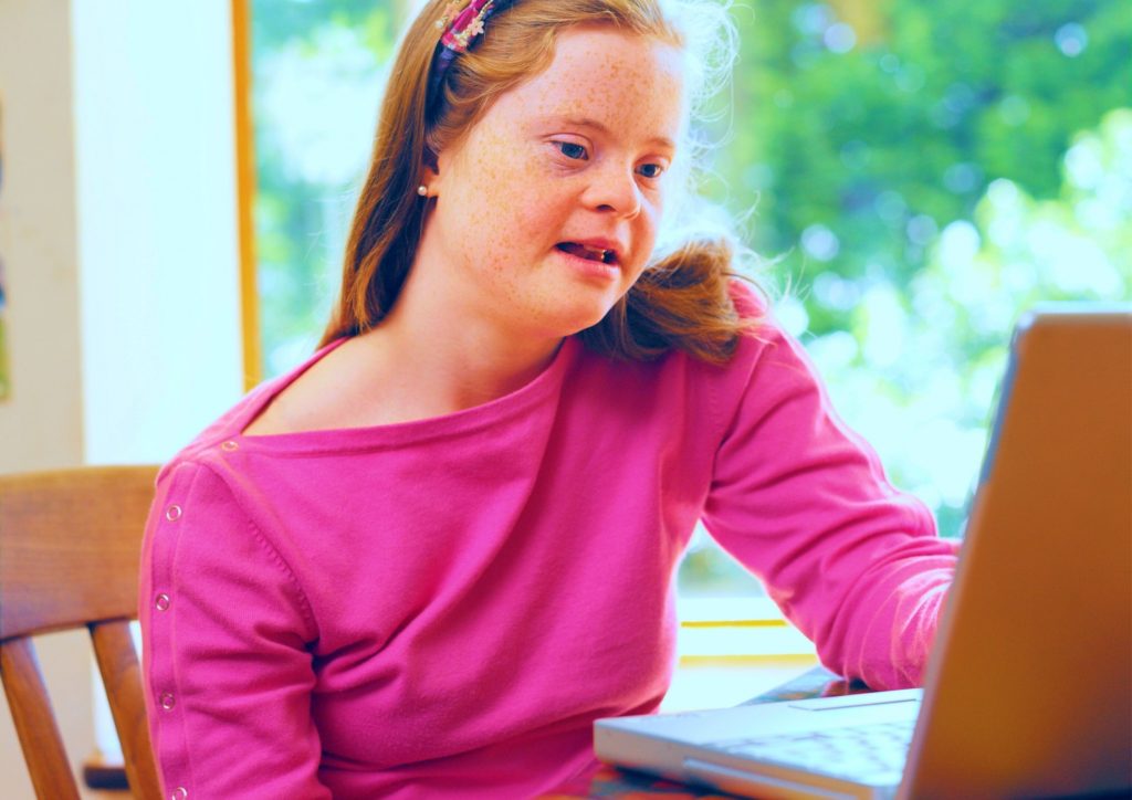 Young girl with down syndrome on her computer
