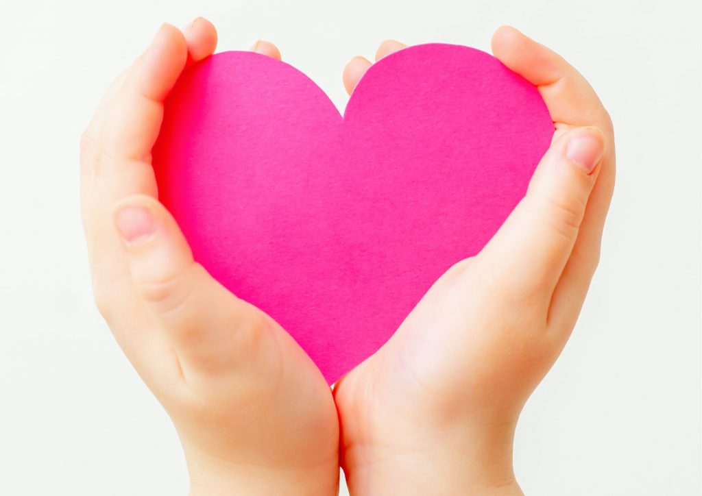 Child holding a pink heart